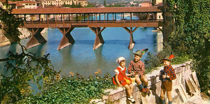 Immagine del 1963 di tre bambini vestiti da alpini con sullo sfondo il leggendario ponte di Bassano